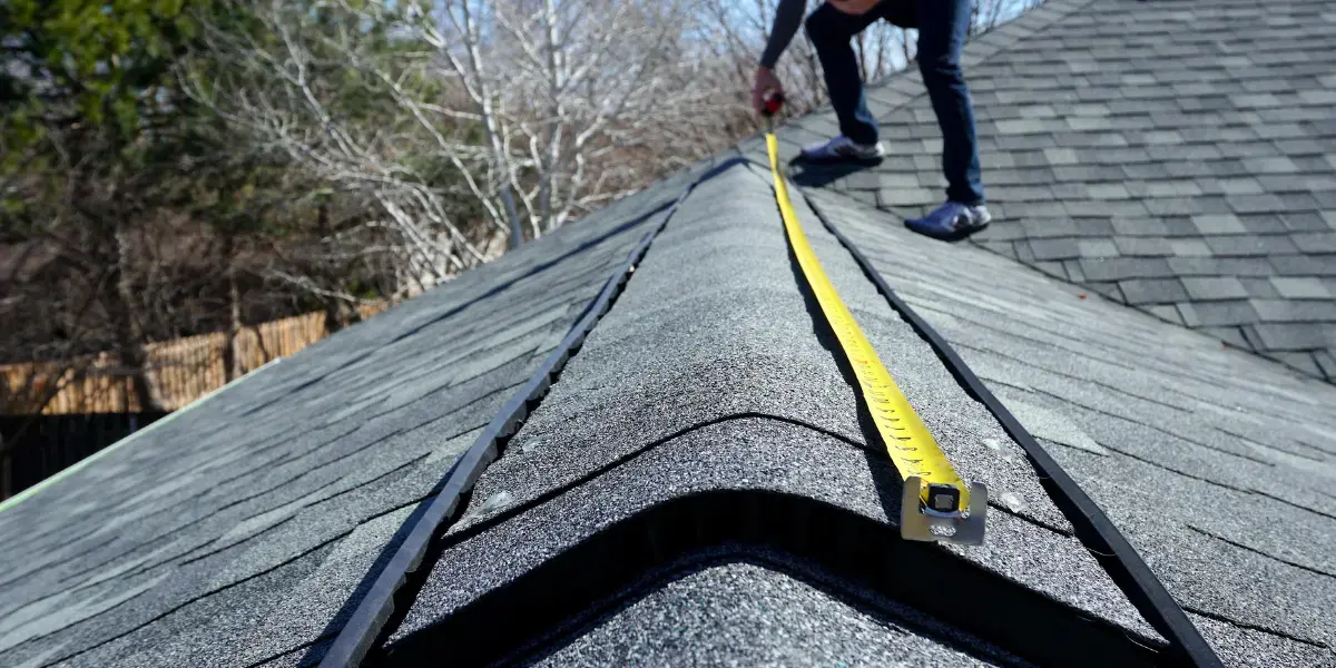 A contractor using measurements tools in a roof.