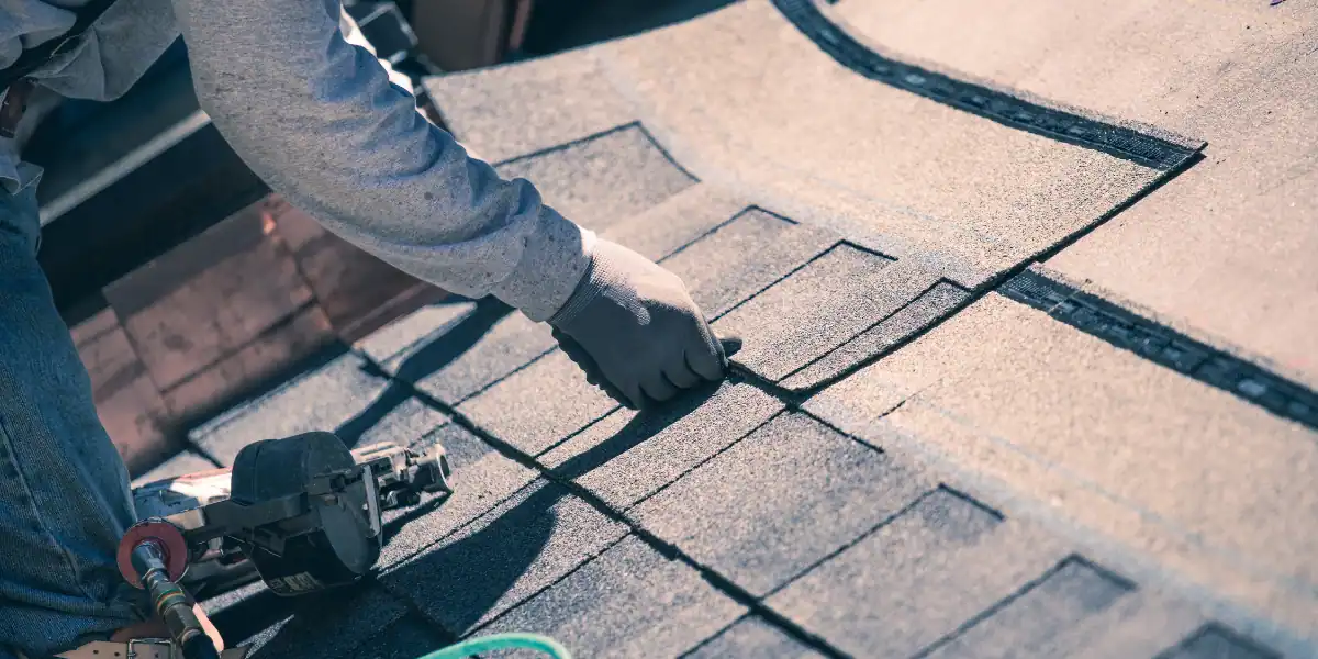  A man engaged in roofing work with a tool, highlighting the importance of understanding claims leakage for adjusters.